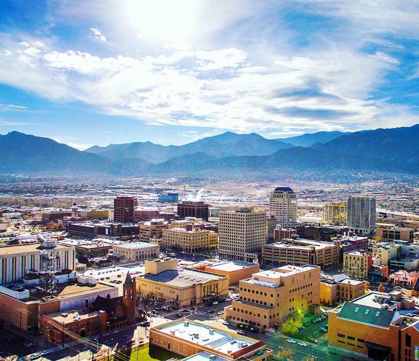 Colorado Springs, Colorado city with mountains in the background and a cloudy, blue sky